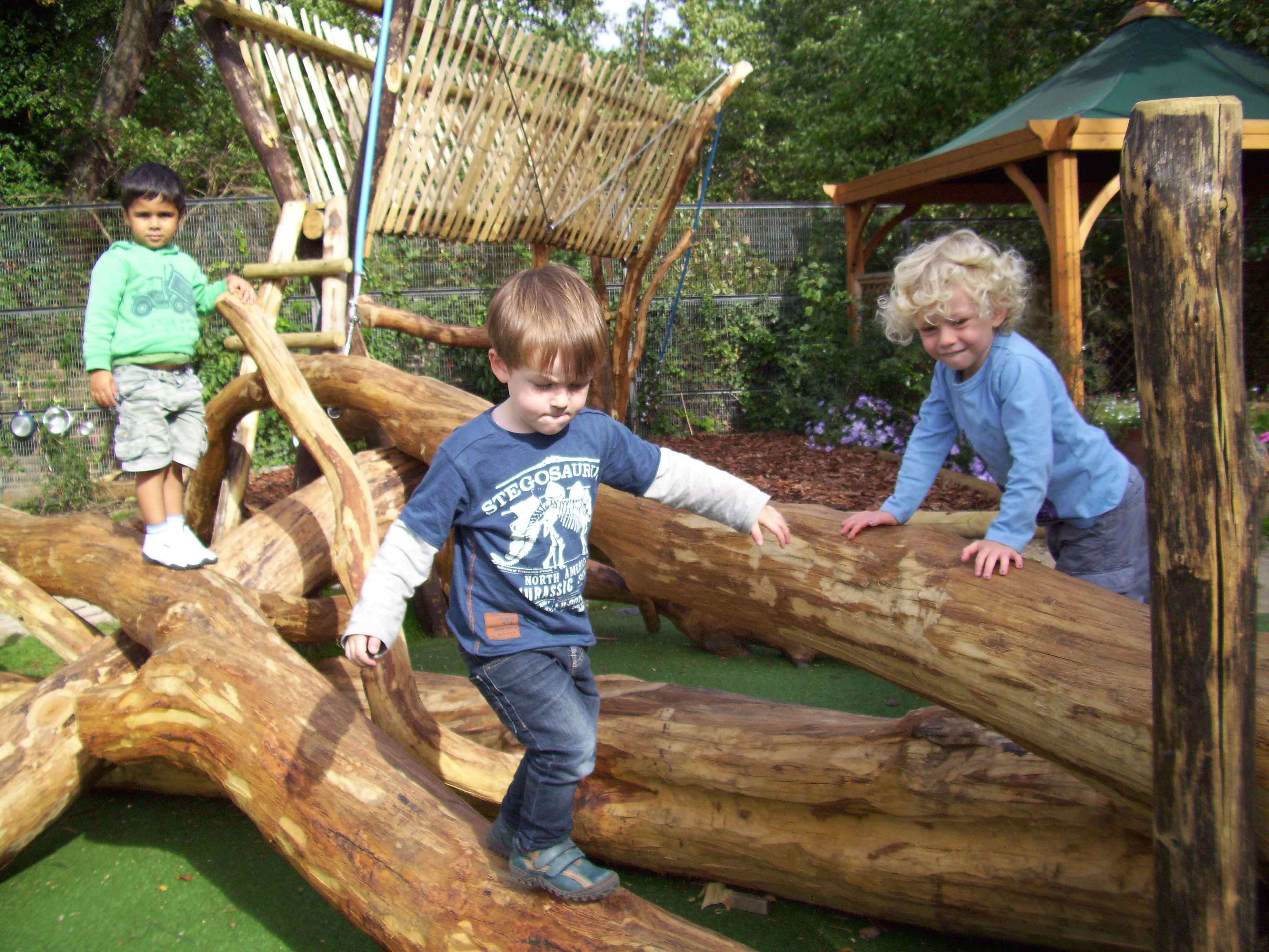 Young children balancing along a carved timber log trail