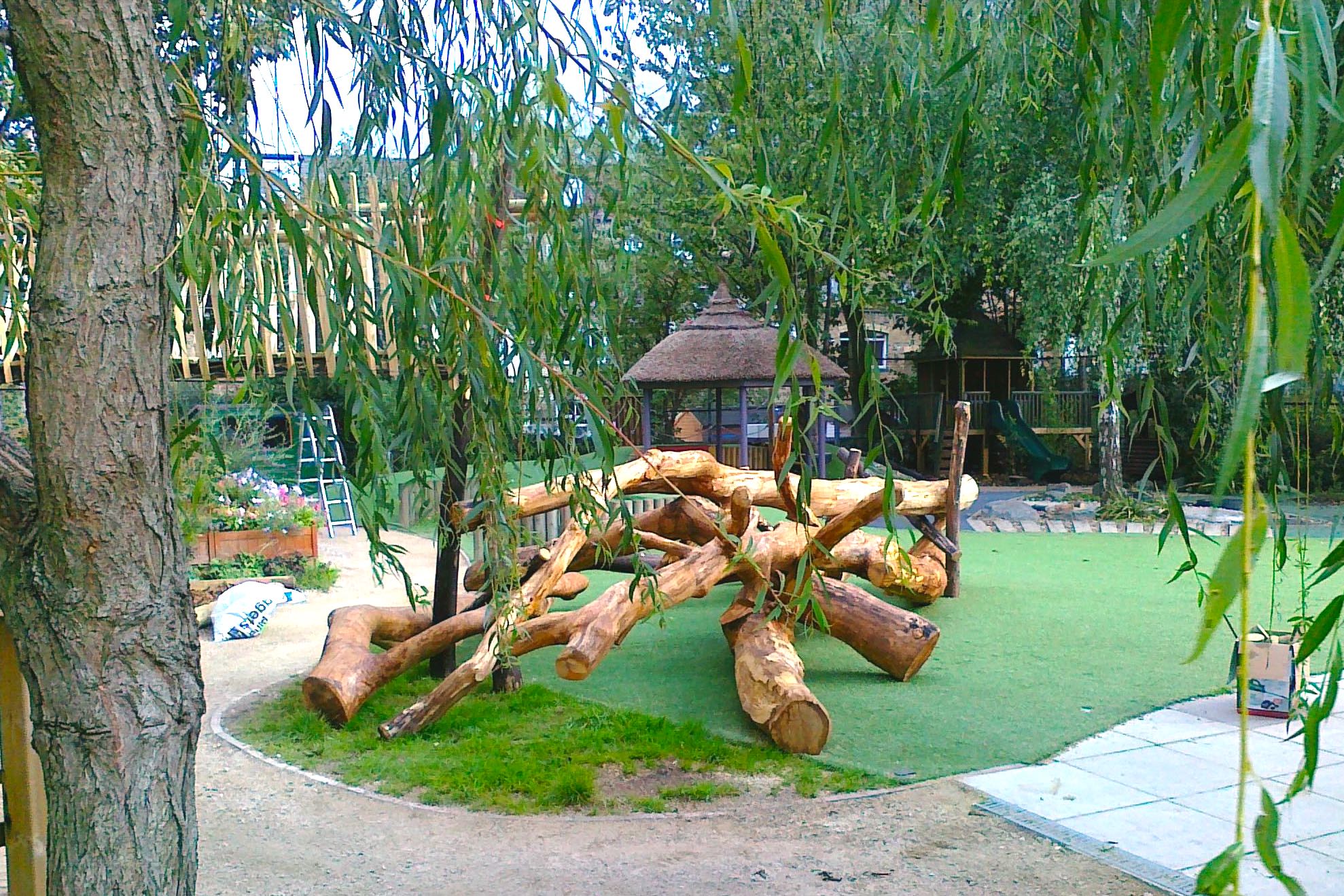 Outdoor mud kitchen with timber counters and real pans